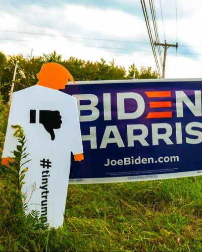 Photograph of a tiny trump lawn sign shown next to a Biden/Harris lawn sign.