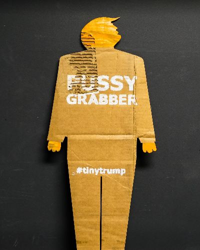 Same as previous image except the slogan is Pussy Grabber.