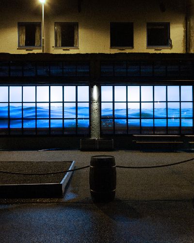 Tight shot of Water Will Be Here projected into the windows of Molo Brew