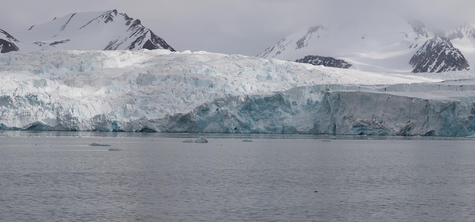Panoramic photograph three of five: not much has changed, honestly. The camera continues its pan to the right, revealing more of the same glacier and snow-covered mountains.