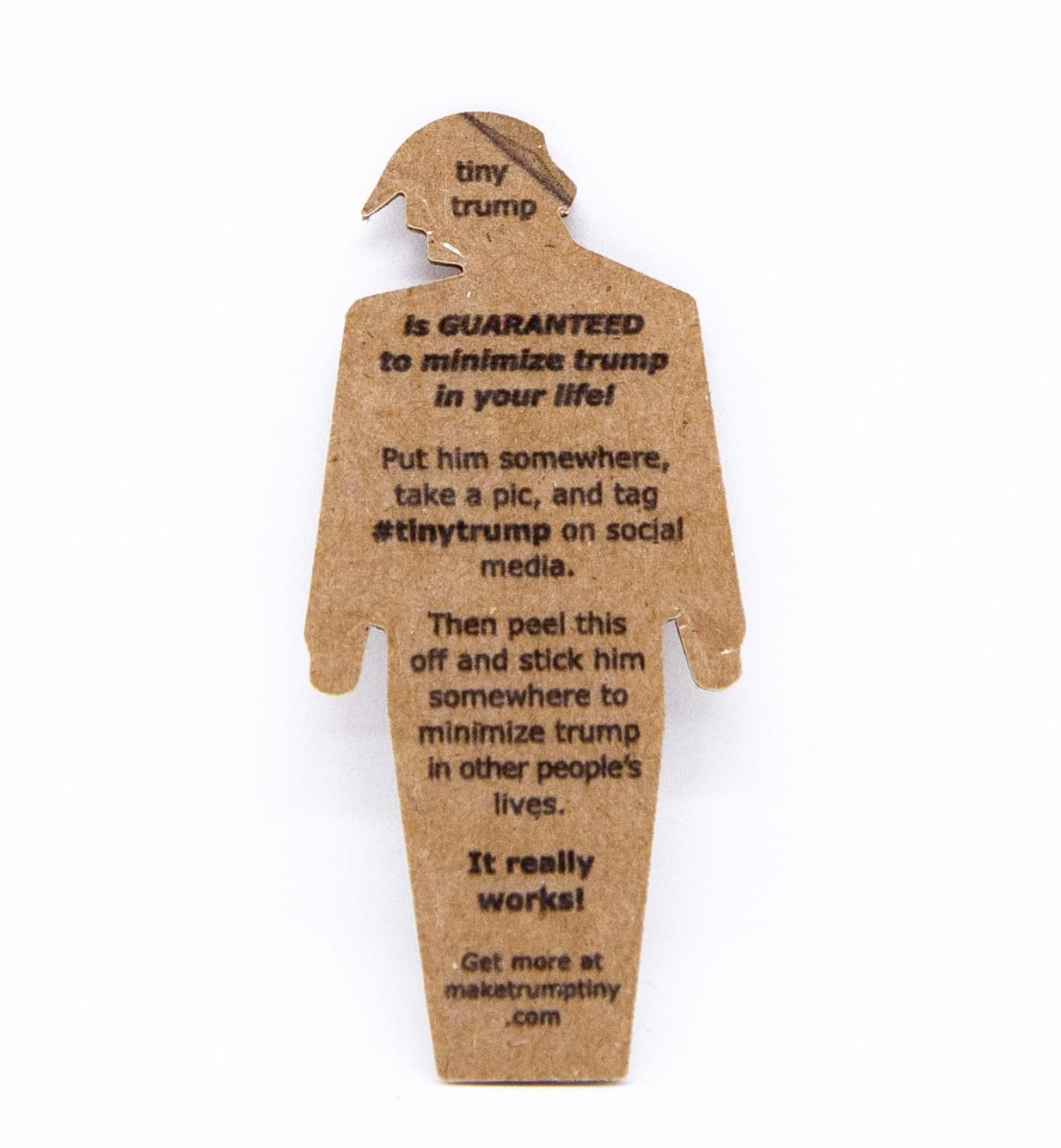 The back of a tiny trump reads: tiny trump is guaranteed to minimize trump in your life. Put him somewhere, take a pic, and tag #tinytrump on social media. Then peel this off and stick him somewhere to minimize trump in other people\'s lives. It really works! Get more at maketrumptiny.com